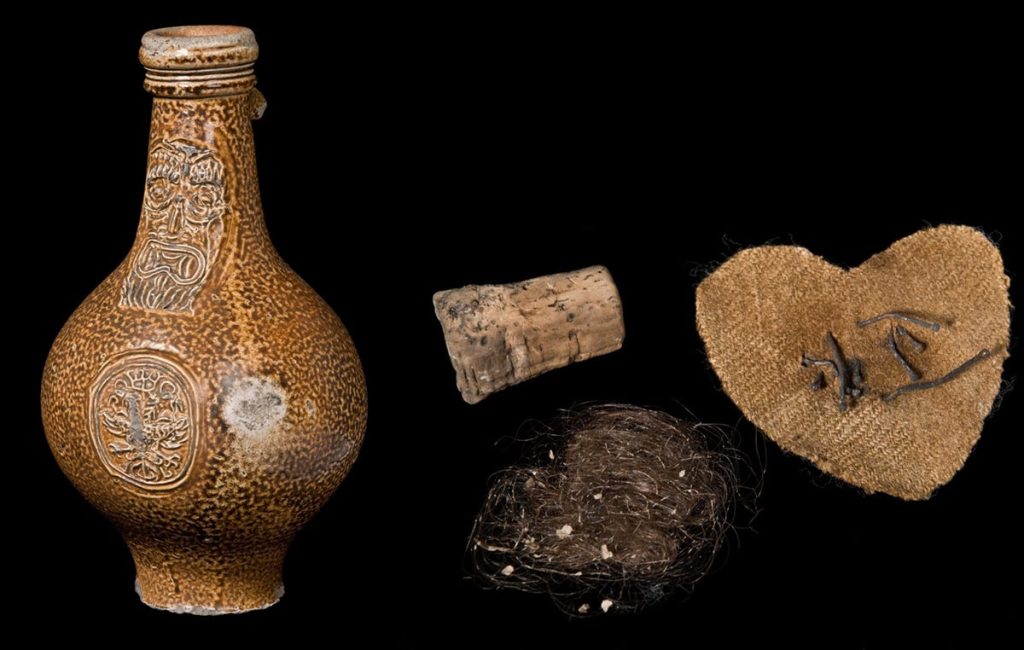 Botella de bruja hecha con jarra belarmina, encontrada en la Abadía de Westminster en 1904, y sus contenido.